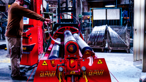 Welder rolling a large thin stainless steel cylinder